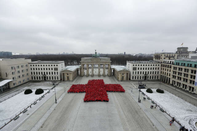 1800 ehrenamtliche DRK Helfer bilden ein rotes Kreuz vor dem Brandenburger Tor. Das Foto wurde von oben aufgenommen.