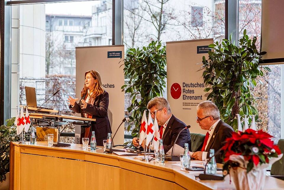 Frau Trautmann steht am Podium und spricht zu den Anwesenden.