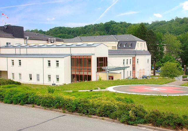 Das DRK Krankenhaus Lichtenstein ist zu sehen. Neben dem Krankenhaus ist ein großer Hubschrauberlandeplatz.