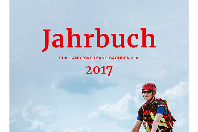 Auf dem Cover des Jahrbuches des DRK Landesverbandes Sachsen für das Jahr 2017 ist ein Mitarbeiter der Wasserwacht zu sehen. Er fährt gerade mit einem Jetski über ein Gewässer.