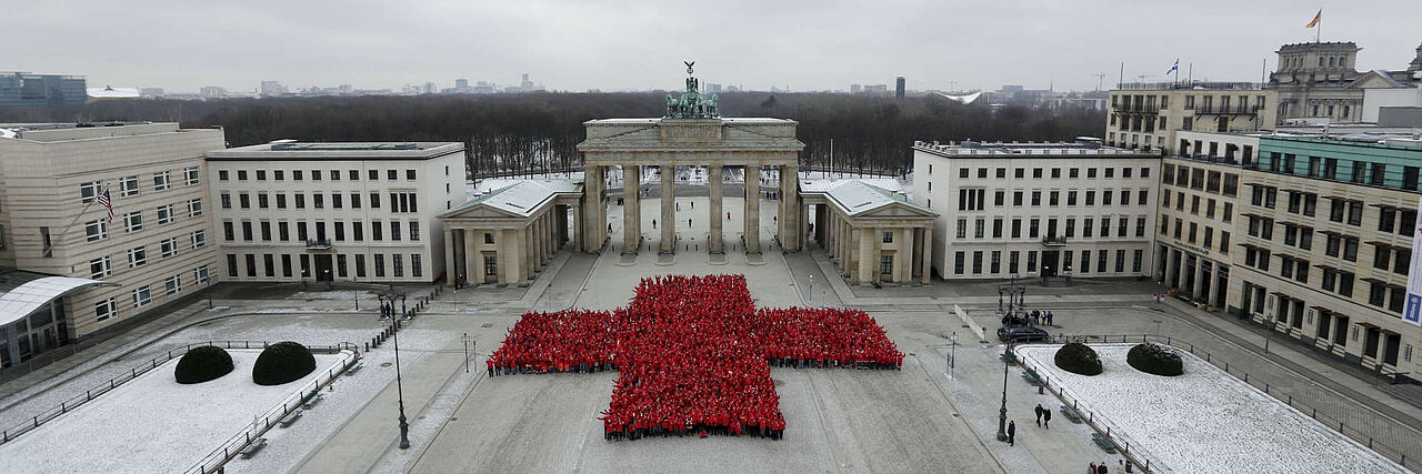Zum 150. Jubiläum des Deutschen Roten Kreuzes bildeten 1.800 Ehrenamtliche ein rotes Kreuz vor dem Brandenburger Tor. Das Foto zeigt die formierte Menschenmenge von oben.