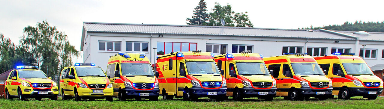 Die Flotte von Einsatzfahrzeugen des DRK Kreiverbandes Pirna steht nebeneinander. Alle Fahrzeuge sind, wie in Sachsen typisch, gelb.