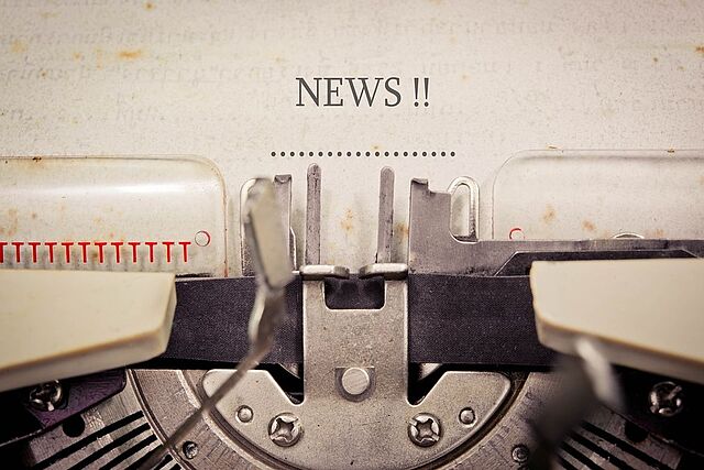 Eine Schreibmaschine ist in Nahaufnahme zu sehen. Auf dem Blatt in der Schreibmaschine steht das englische Wort "News" für "Nachrichten".