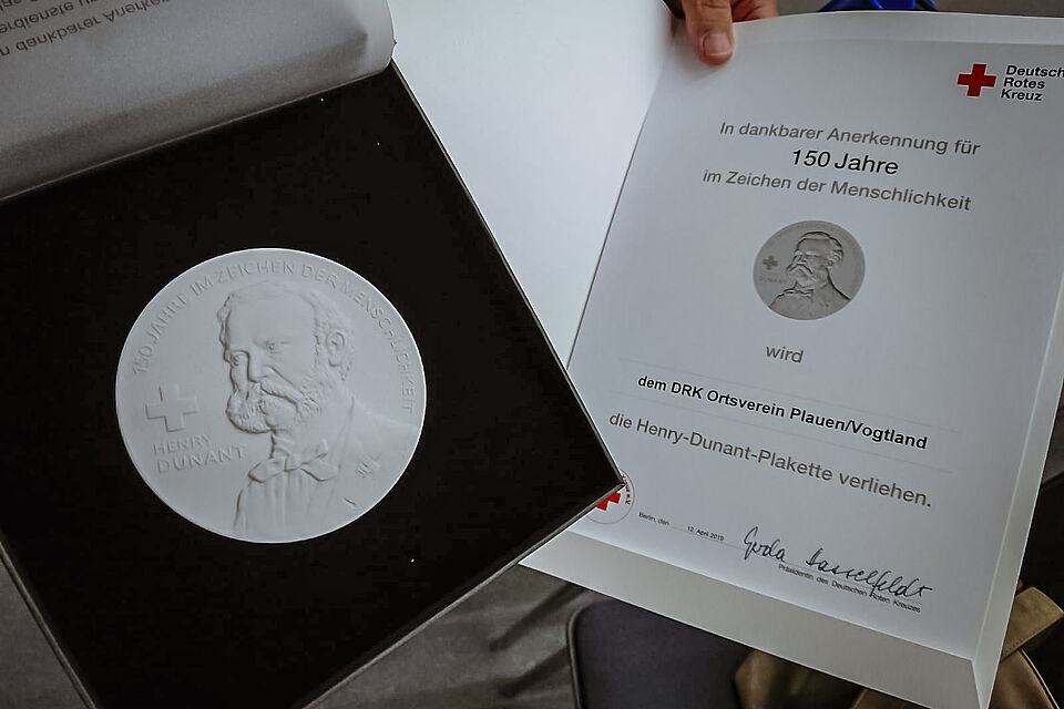 Foto einer Henry Dunant Medaille und Urkunde