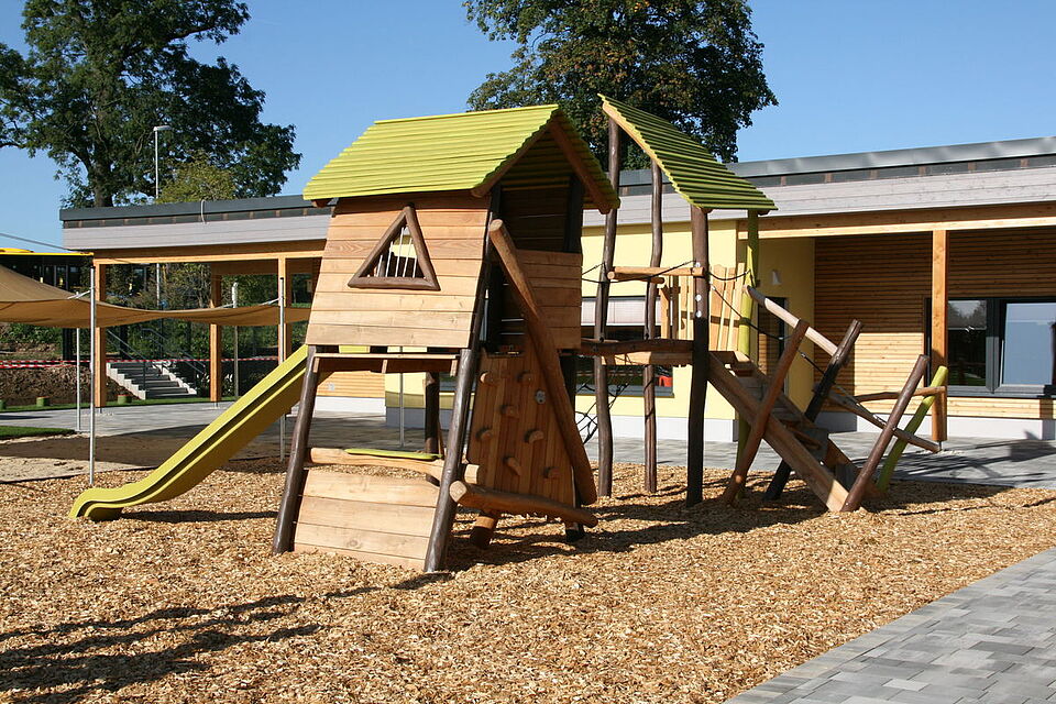 Kinderspielplatz mit Rutsche und Kletterhaus im Außenbereich