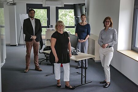 Sächsische Opferbeauftragte, Iris Kloppich und Dr. Nicole Porzig, Deutschen Rotes Kreuz Landesverbandes Sachsen posieren im Führungs- und Lagezentrum für ein Foto. Natürlich mit einem Mindestabstand von 1,5 Metern. Im Hintergrund stehen Innocent Töpper vom DRK Kreisverband Dresden-Land und eine Mitarbeiterin der Opferbeauftragten