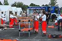 Viele Helferinnen und Helfer arbeiten in einer Zeltstadt für geflüchtete Menschen. 