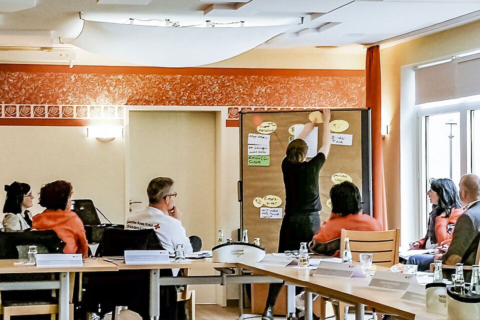 Mitarbeiter des DRK Suchdienstes beraten sich auf einer Fachtagung.